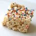 A piece of rice krispie treat with sprinkles on top.
