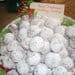 A bowl of powdered sugar covered cookies.