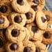 A pile of cookies with chocolate chips on top.