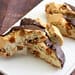 A white plate topped with pieces of chocolate covered cookies.