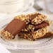 A plate of chocolate and peanut brittle on top of a table.