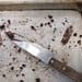 A knife and some brown spots on the floor